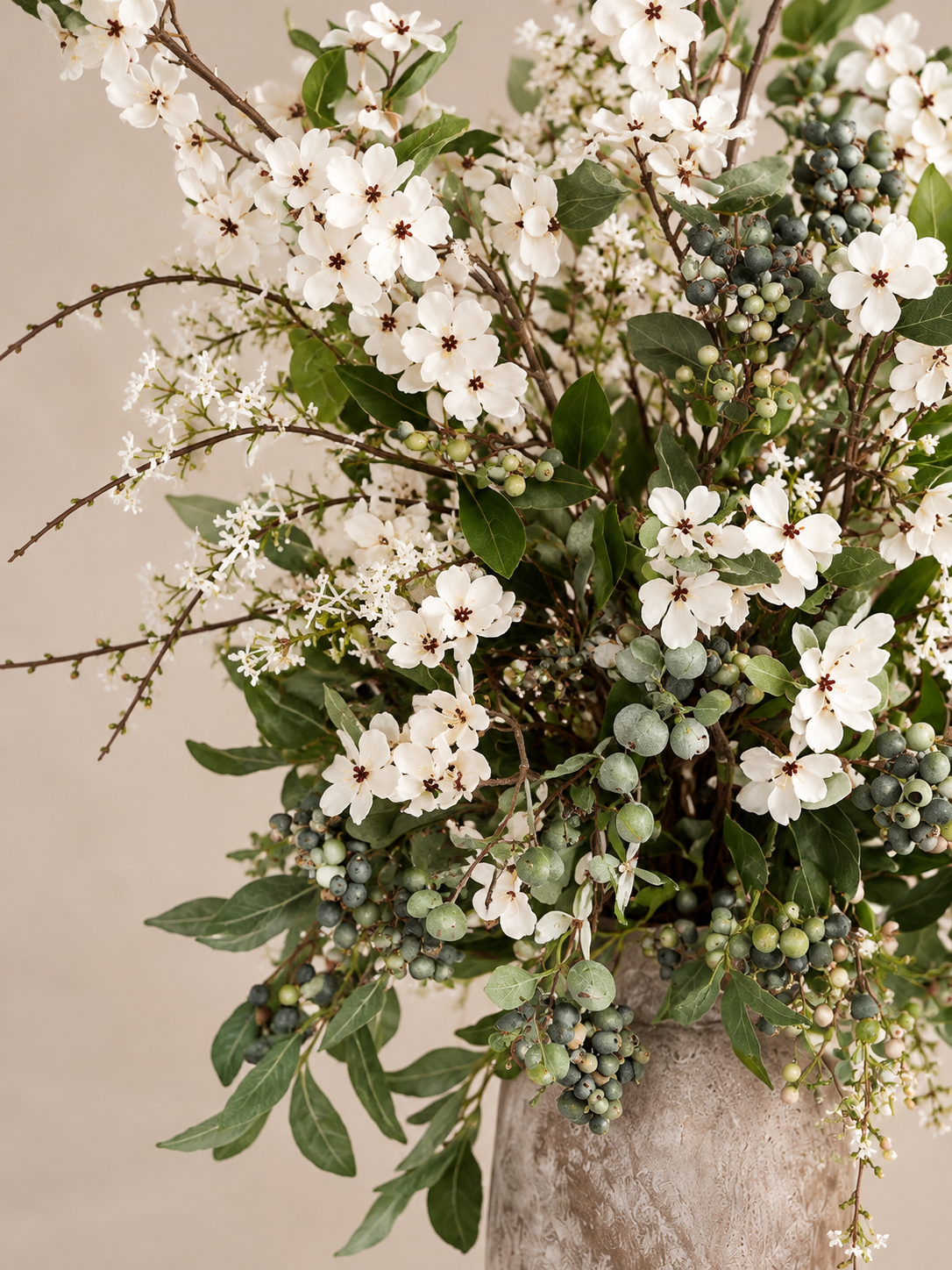 Close-up of Daphne white blossoms, layered greenery and berry-like details