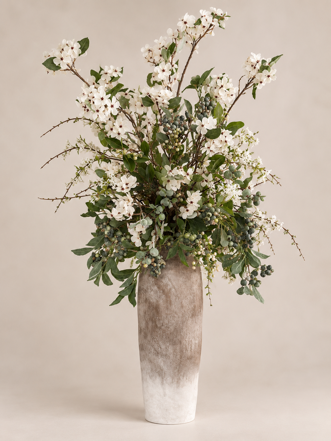 Daphne white floral arrangement with greenery and berry-like details in a textured ombre vase